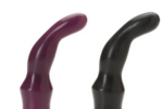 Two Tantus Protouches side-by-side, wine-colored and black. It is shaped, overall, somewhat like a finger that is bent at the last knuckle in the fingerm but the toy is thicker from the mid-point to bottom than the "finger" is