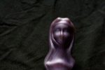 The entirety of the Diving Nun, pictured against a black background. She is a curved dildo with a very wide base, with hands and a rosary sculpted in the middle.
